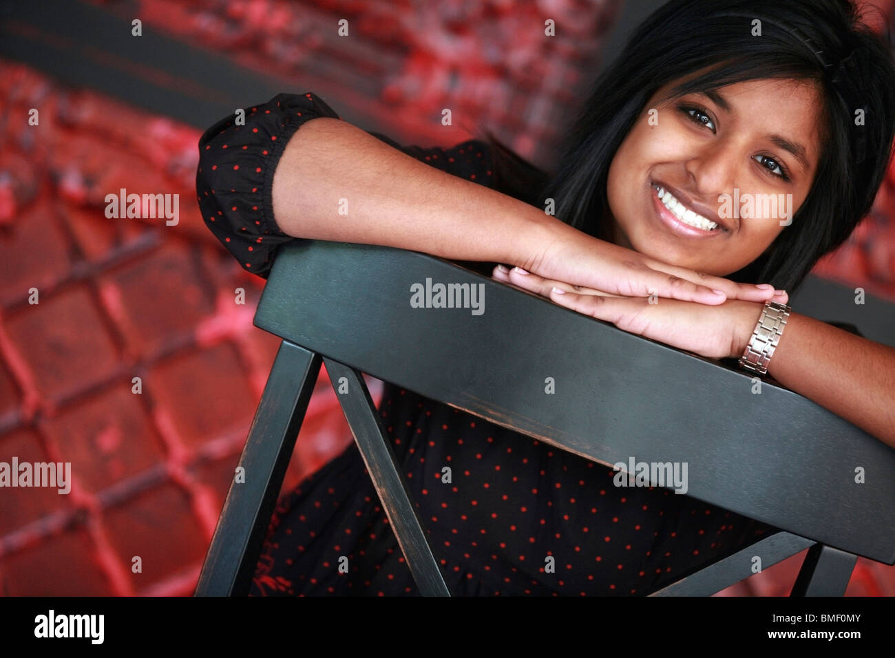 Portrait Of A Young Woman Sitting In A Chair Stock Photo