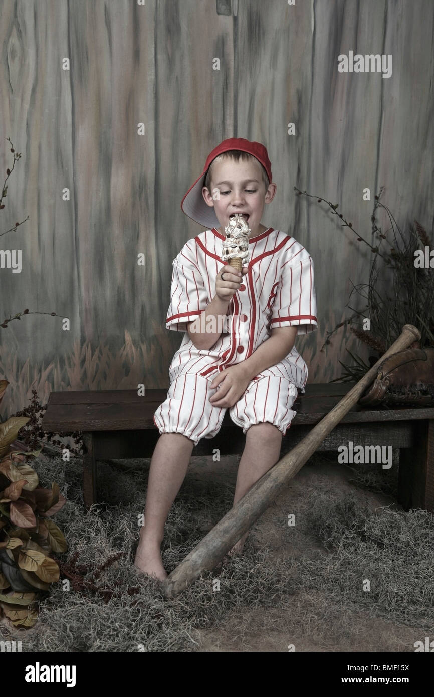 A Boy Wearing A Baseball Uniform And Eating An Ice Cream Cone Stock Photo