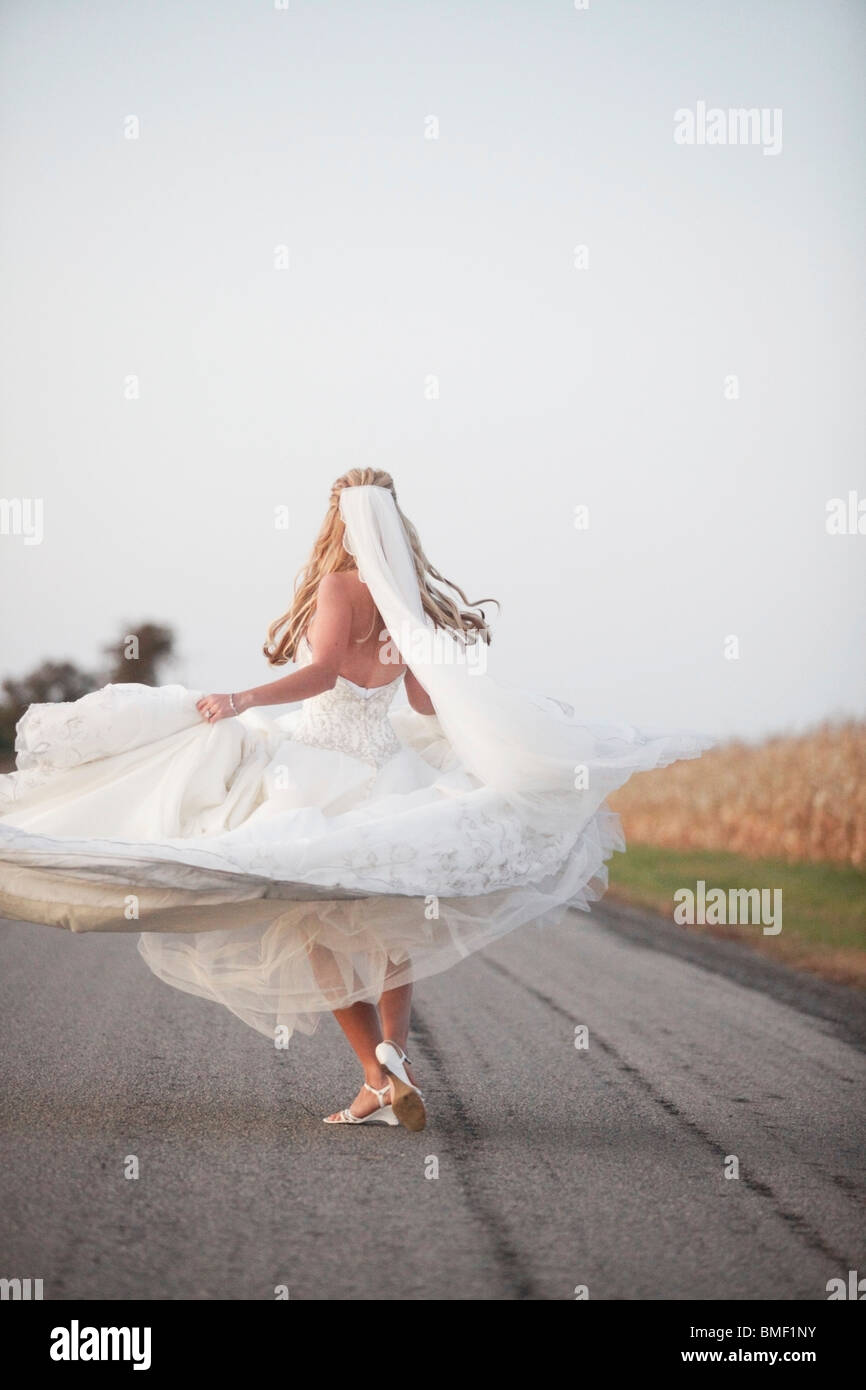 A Bride Spinning In Her Dress On The Road Stock Photo