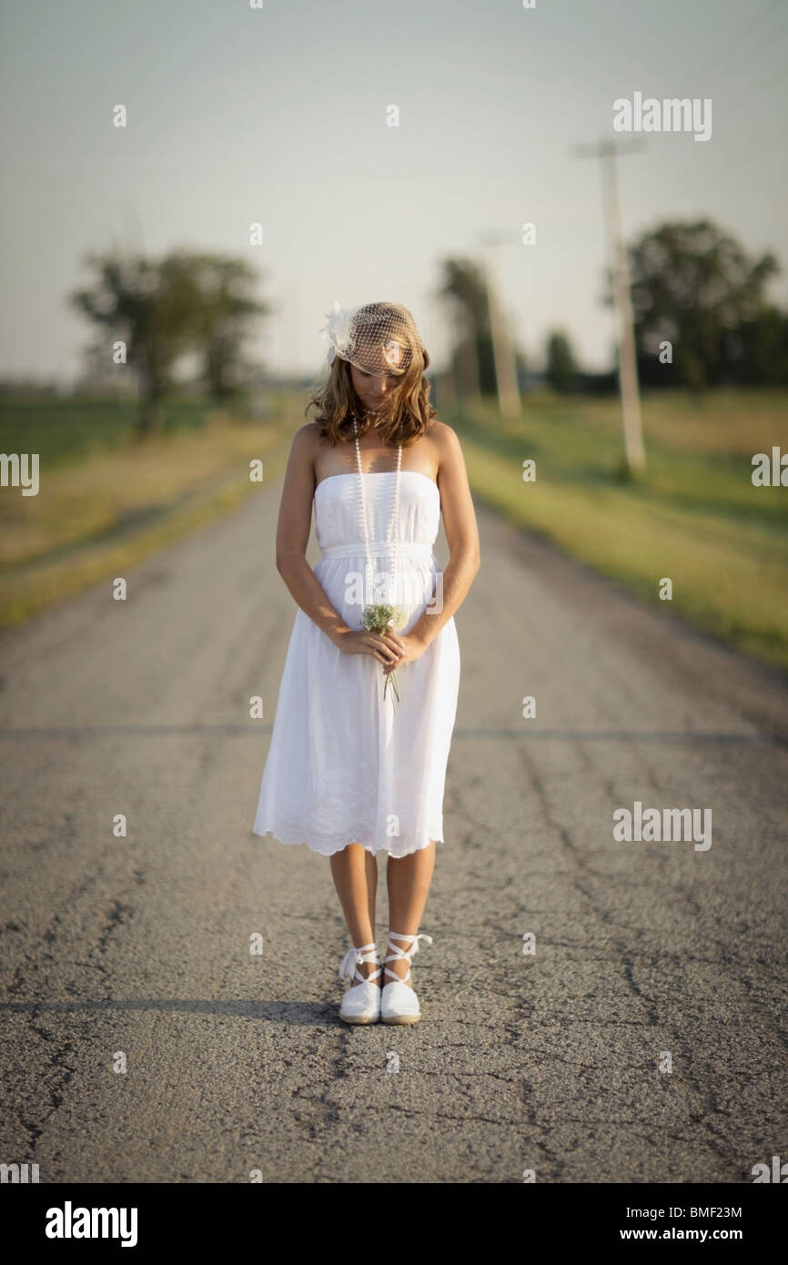A Bride Standing In The Middle Of The Road Stock Photo