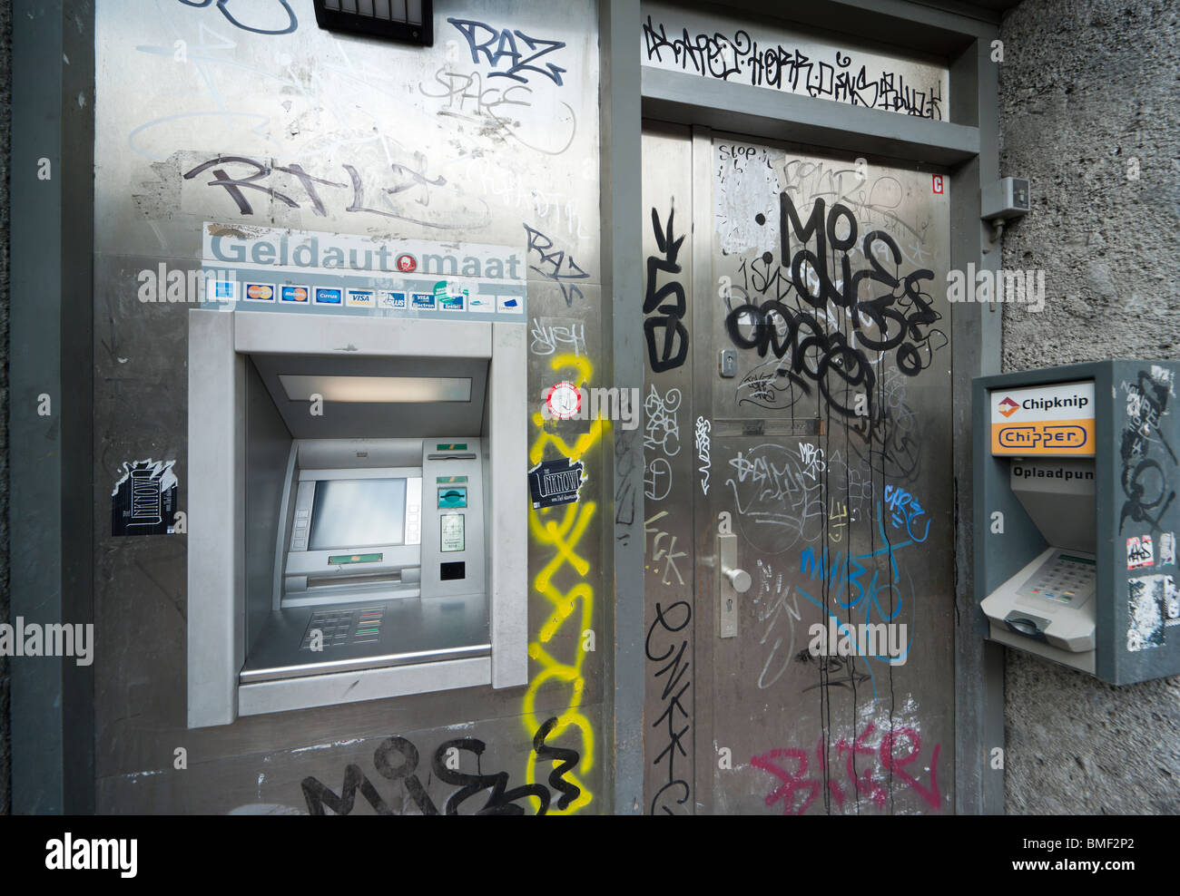 Amsterdam ATM, automatic teller money machine, cashpoint, cash point, in a dirty unclean unsafe corner with ugly graffiti tags. Stock Photo