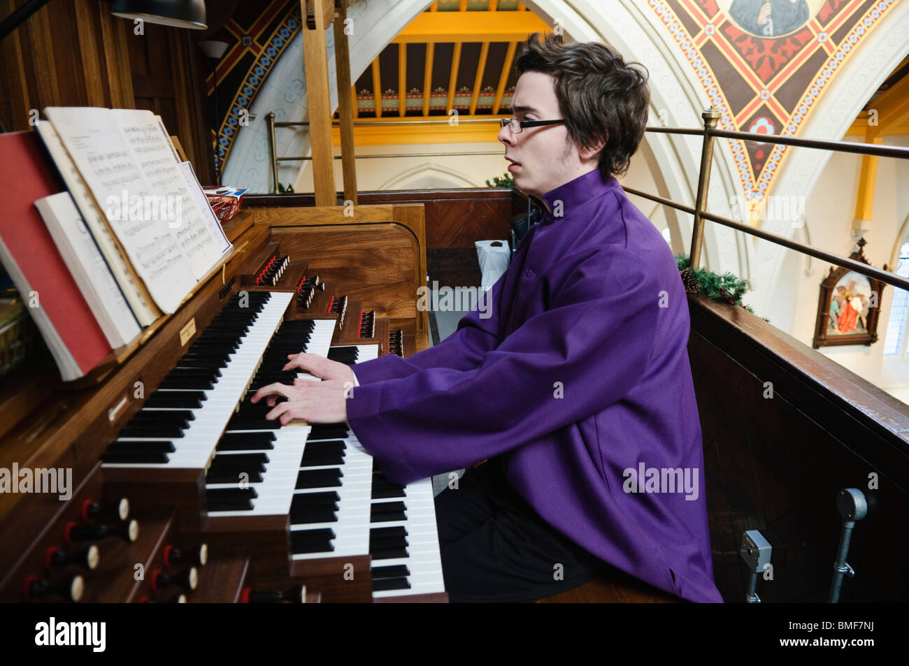 Young male church organist wearing purple robes Stock Photo Alamy