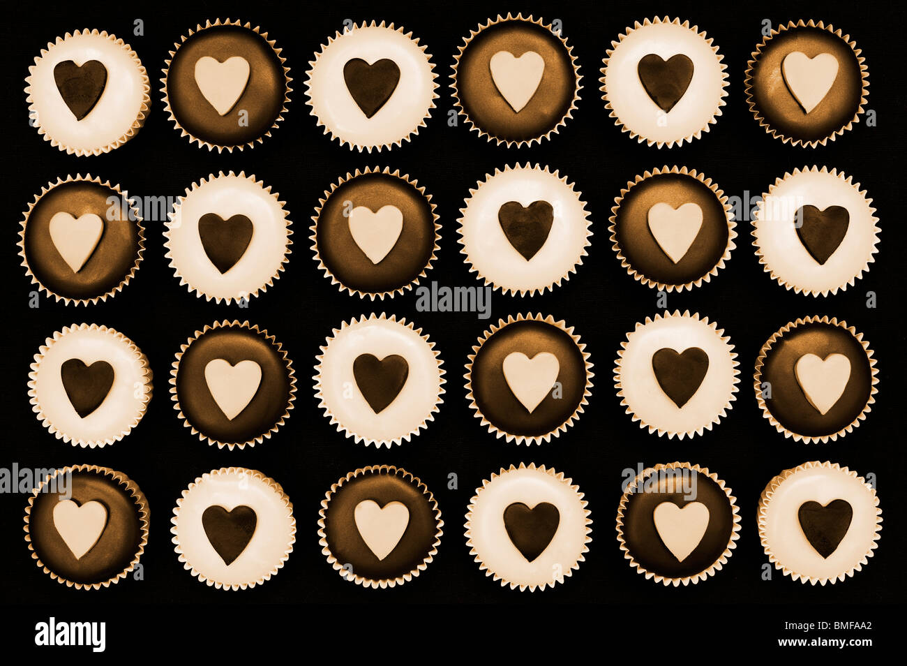 Mini cupcakes decorated with heart shapes. Sepia tone Stock Photo