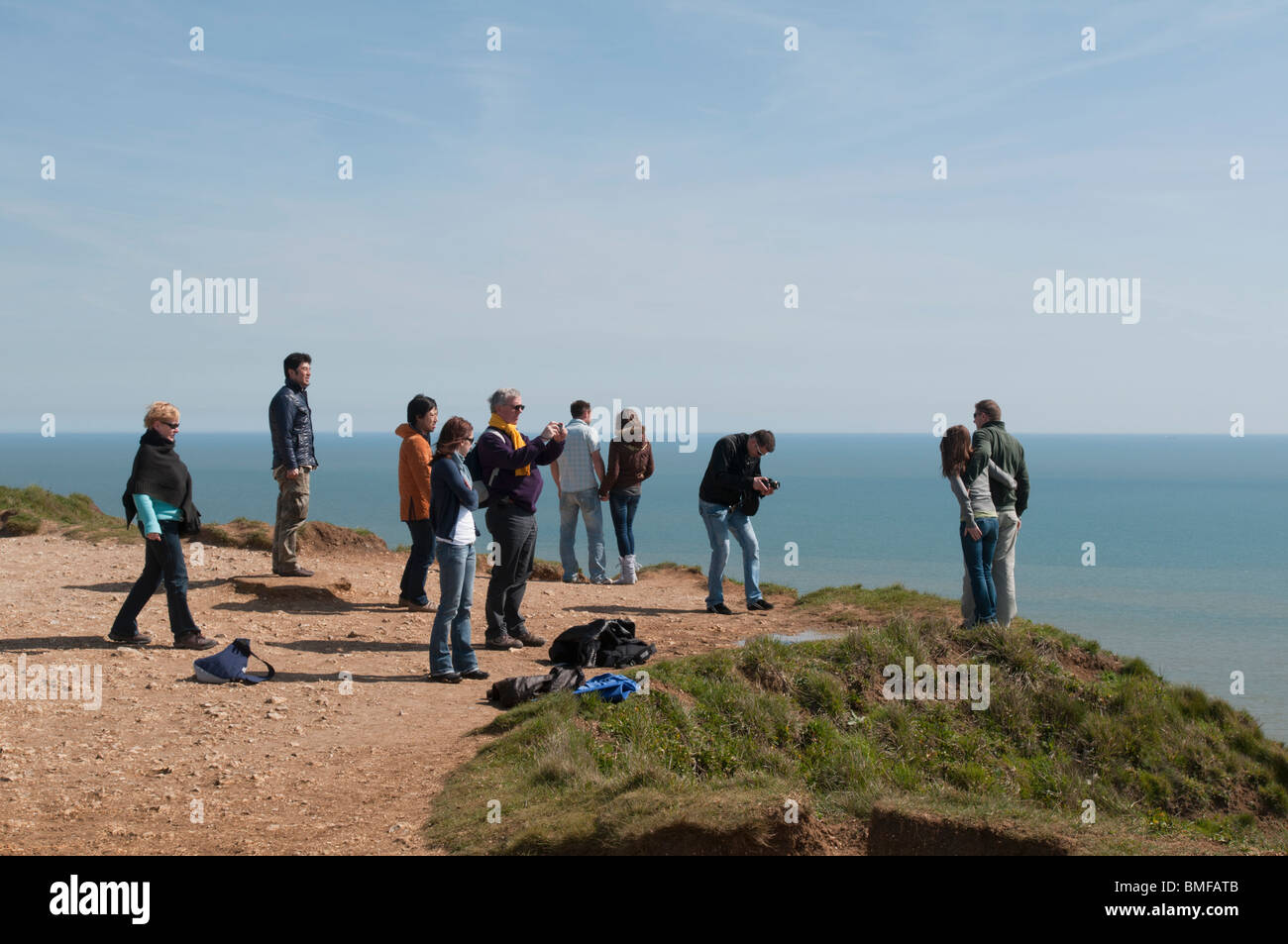 Visitors to Beachy Head take photographs at the cliff edge. EDITORIAL USE ONLY. Stock Photo