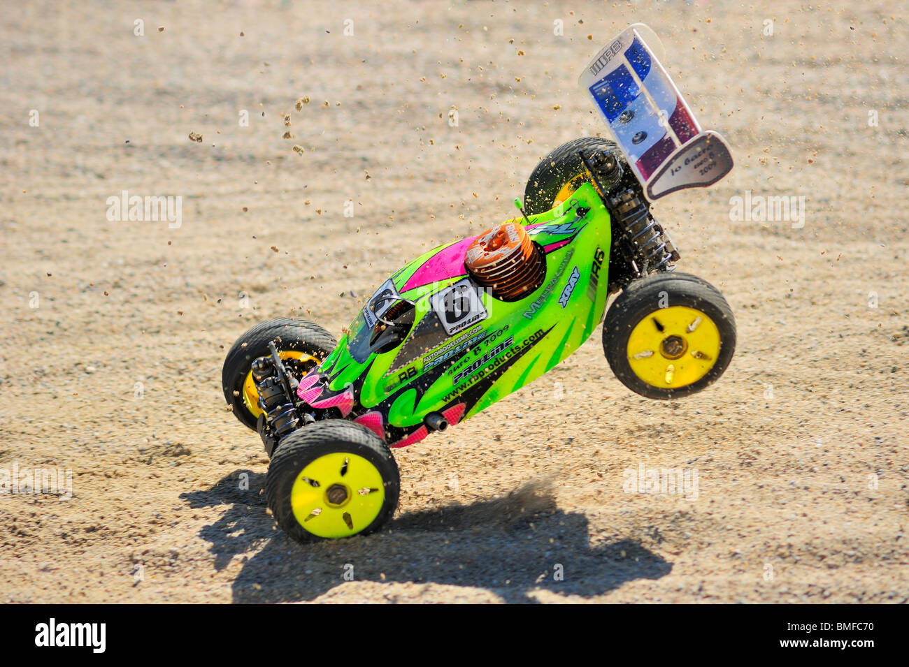 A radiocontrolled model racing car landing at a jump during a race