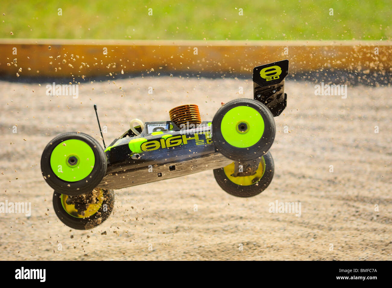 A radiocontrolled model racing car in midair at a jump during a race