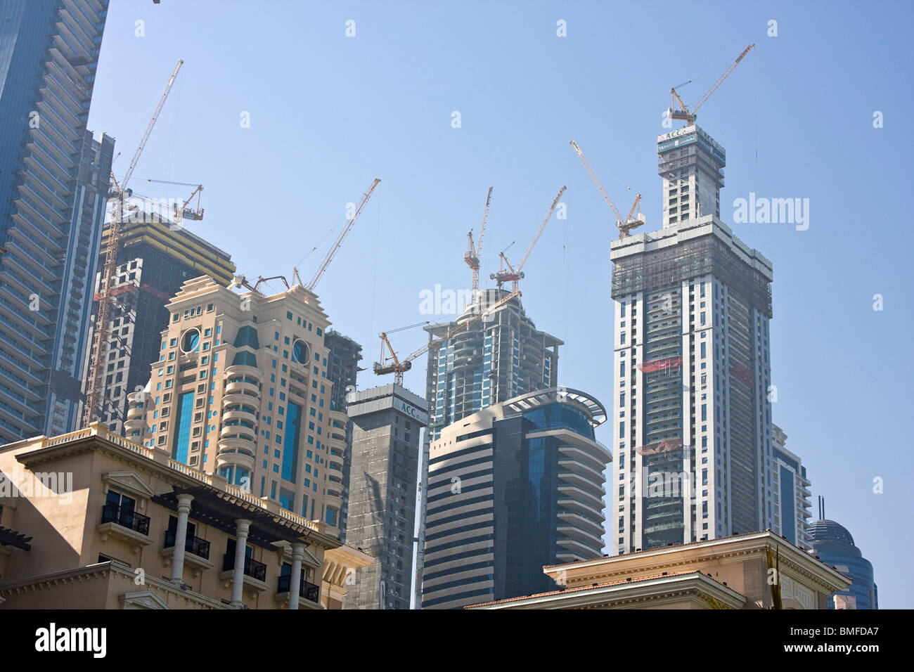 Skyline of Dubai, UAE, with construction cranes atop buildings. Stock Photo