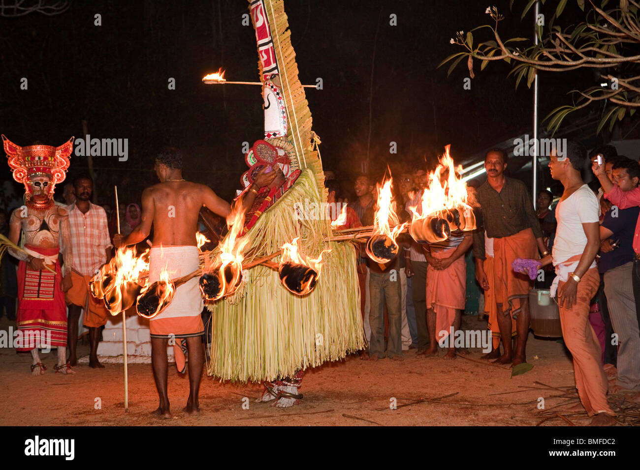 India, Kerala, Cannanore (Kannur), Theyyam, folk art ritual, Agni-Ghandakaran dancing in trance surrounded by flaming torches Stock Photo