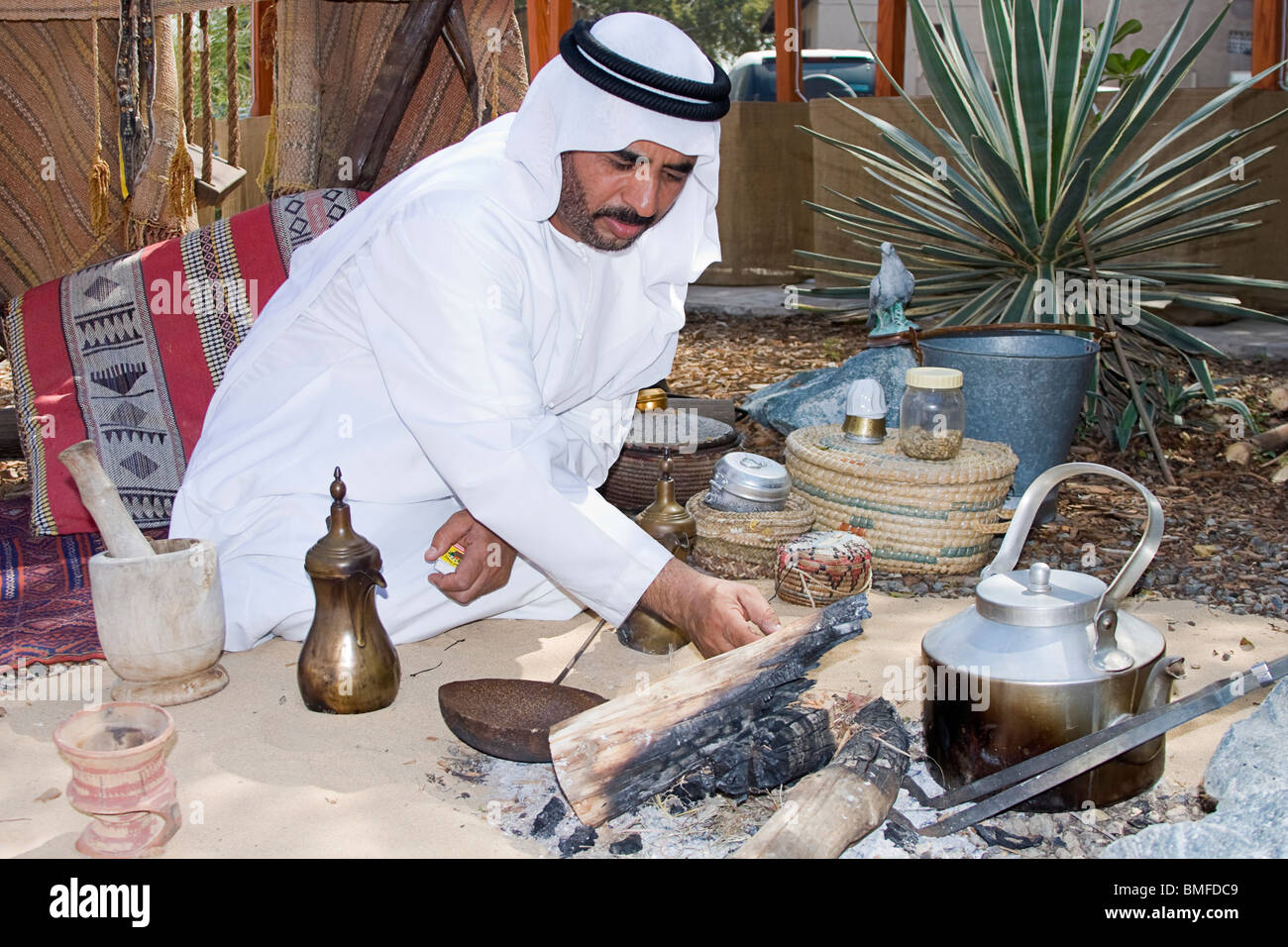 Typical Arab Arab man in typical Arab dress shows how coffee was roasted before ...