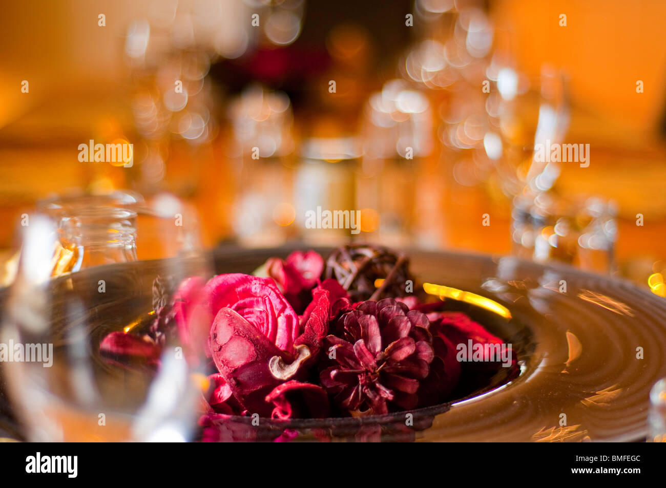 Potpourri bowl arranged on a dining table with wine glasses Stock Photo