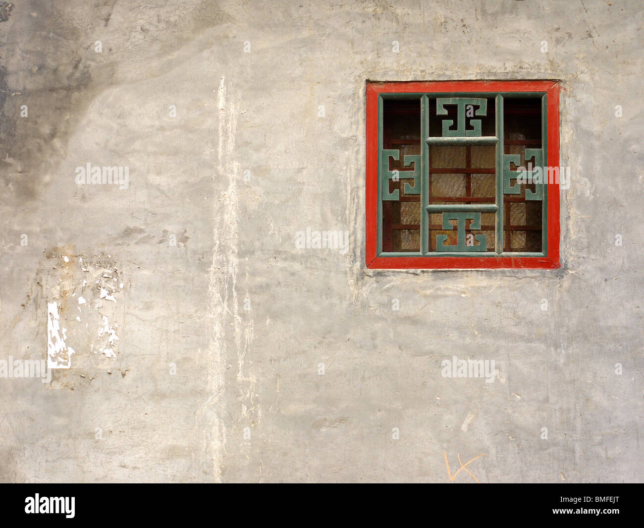 Small traditionally ornate square fan window on the house wall in hutongs, Beijing, China Stock Photo
