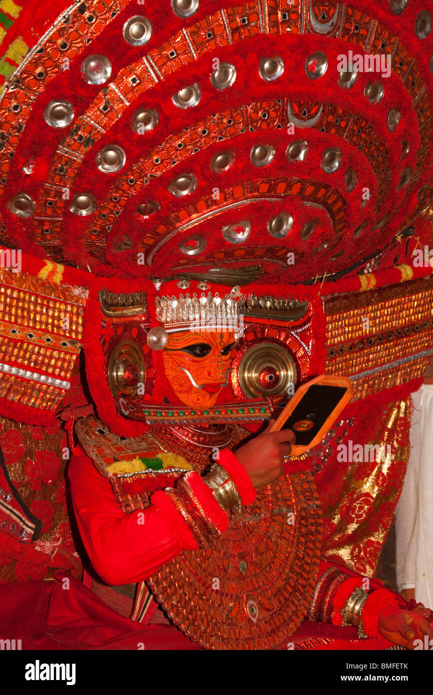 India, Kerala, Cannanore (Kannur), Theyyam, Naga Kanni looking in mirror to become the serpent deity under trance Stock Photo