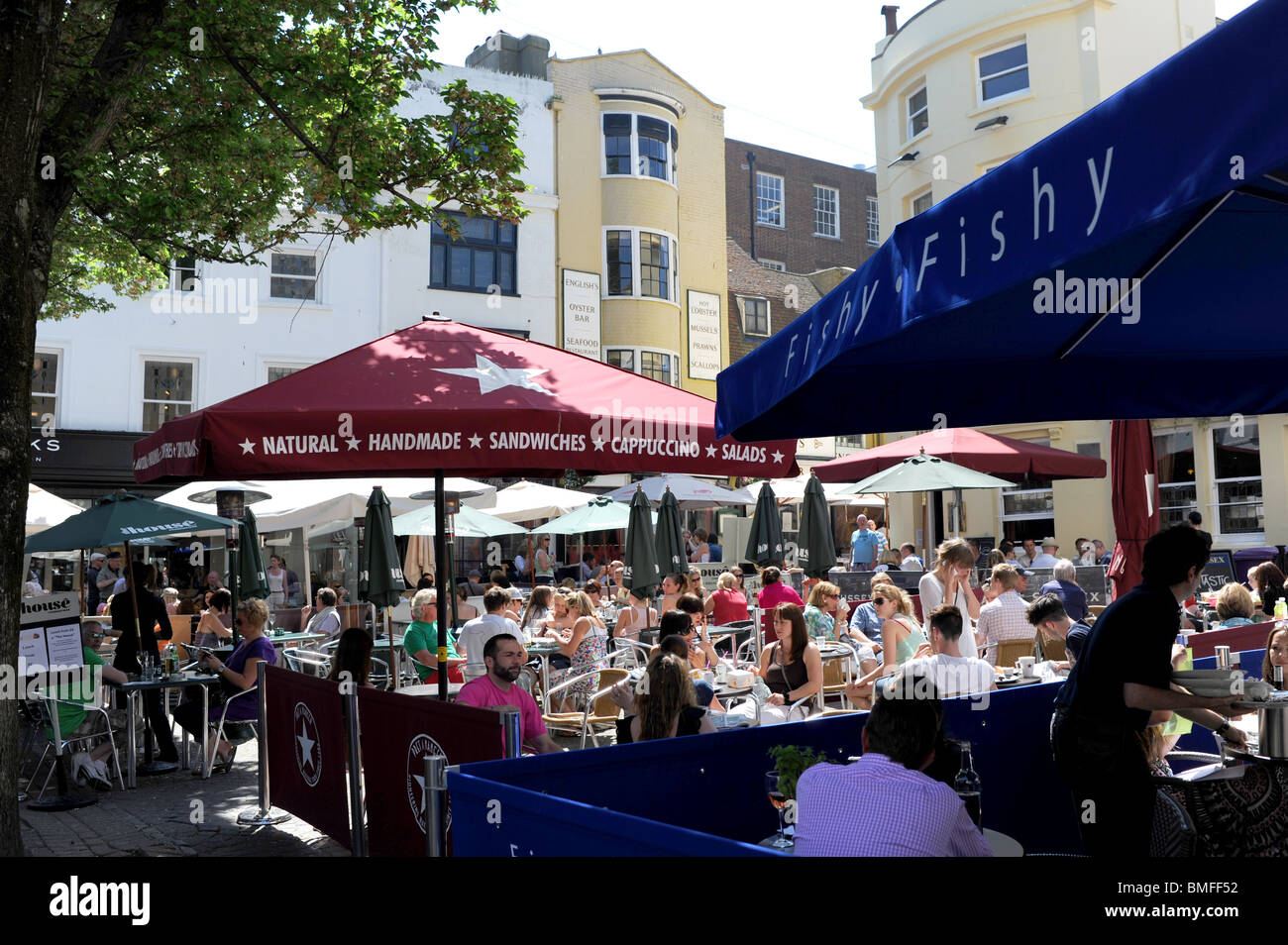 Crowds eating and drinking at pavement cafes and restaurants in The Lanes Brighton city centre