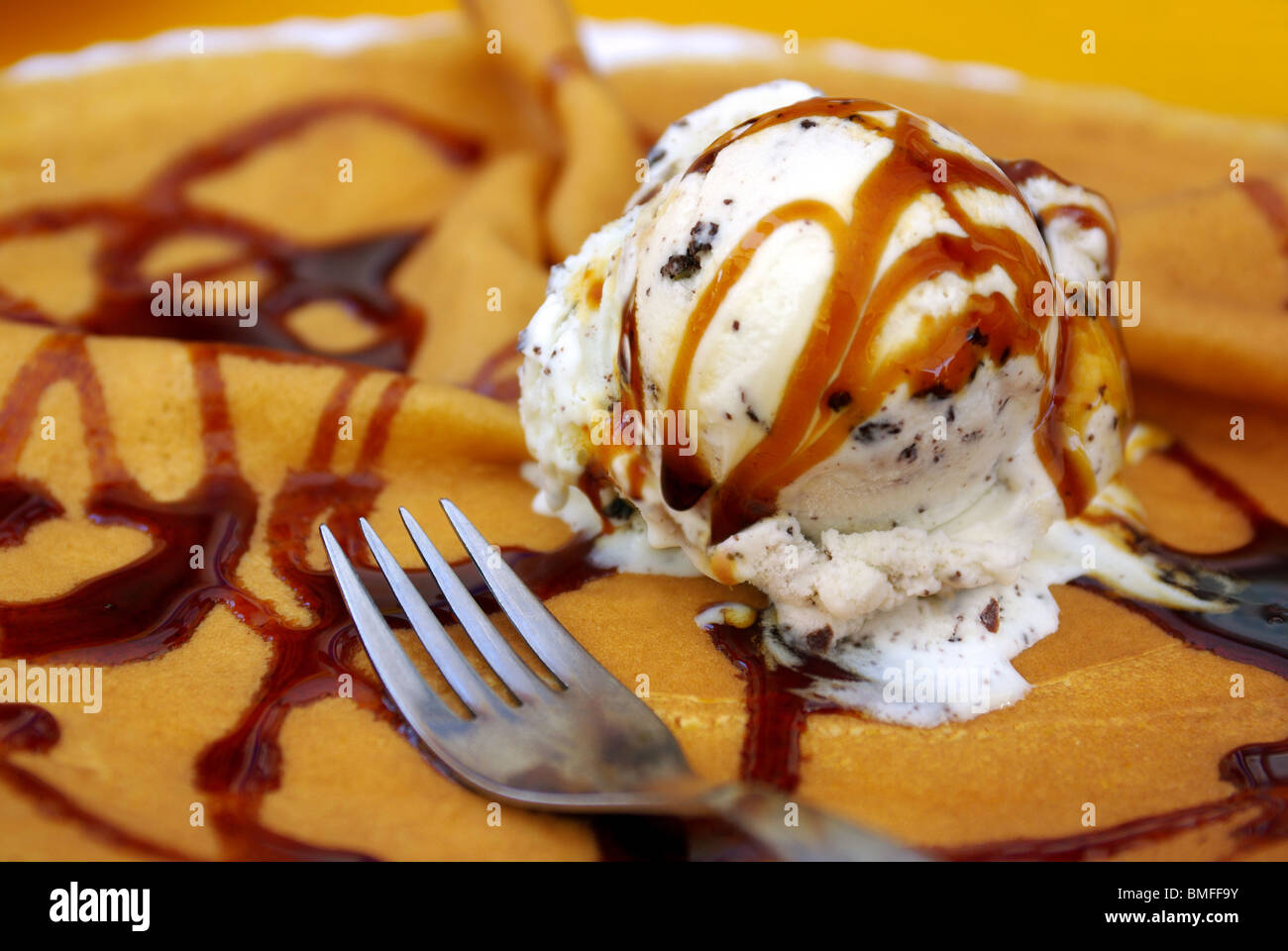 Delicious caramel ice cream over a crepe with chocolate topping Stock Photo