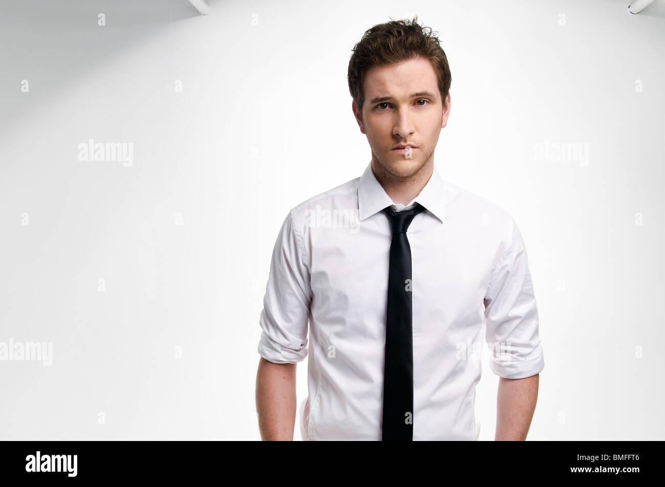 Young man with black tie against white background Stock Photo