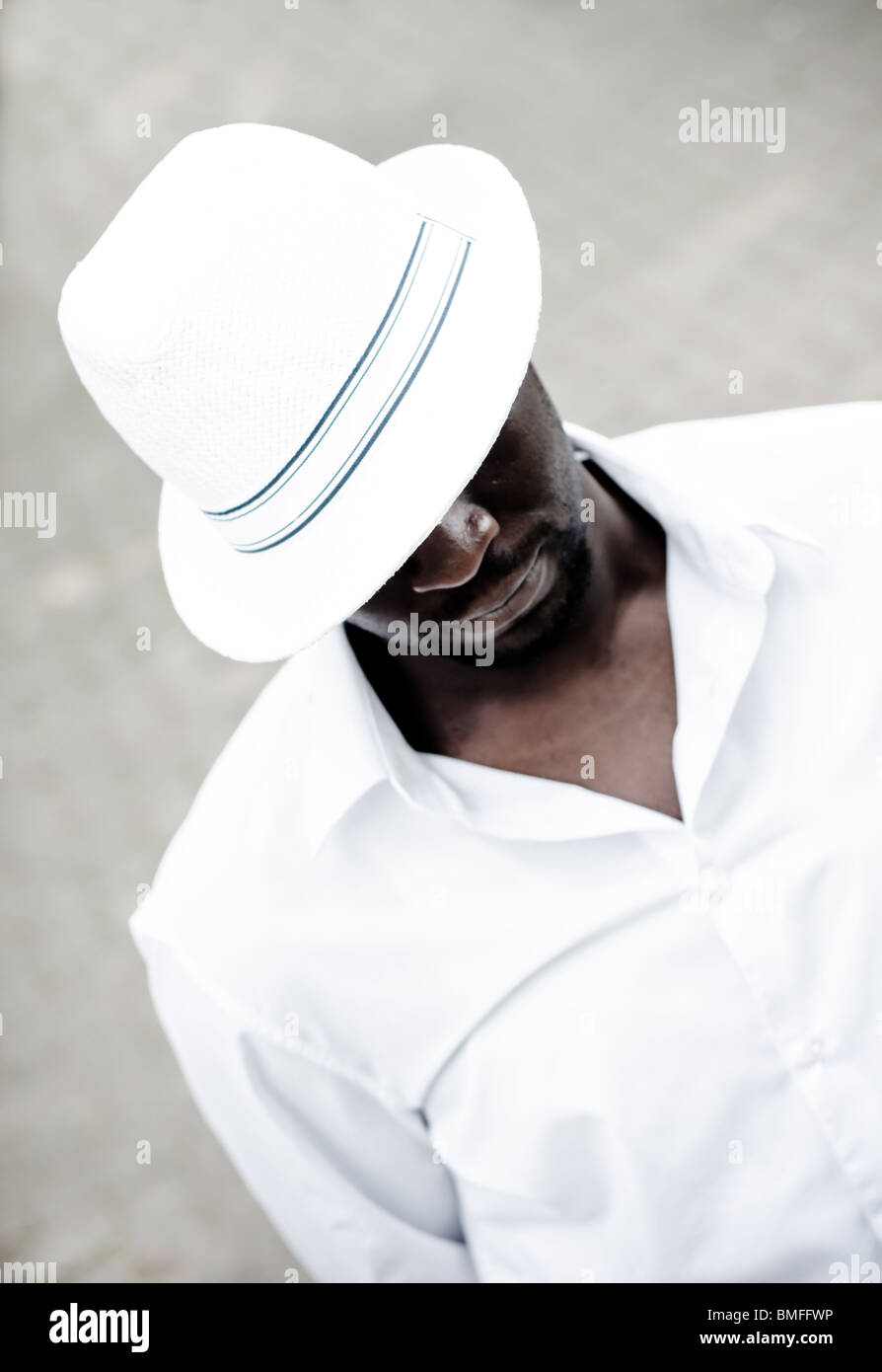 Black man wearing white hat looking down Stock Photo Alamy