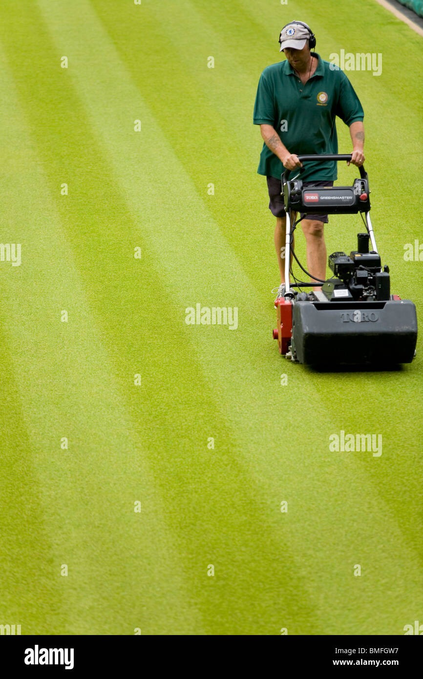 Groundsman cutting the lawn grass at All England Tennis Club, Wimbledon SW19, London. UK. Stock Photo