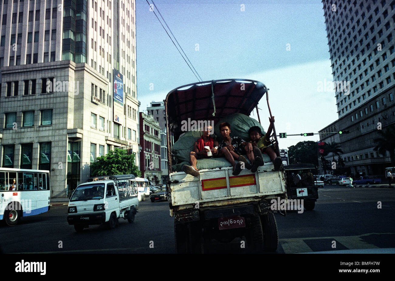 Three teenagers sit in the back of a truck in Yangon, May 2010 Stock