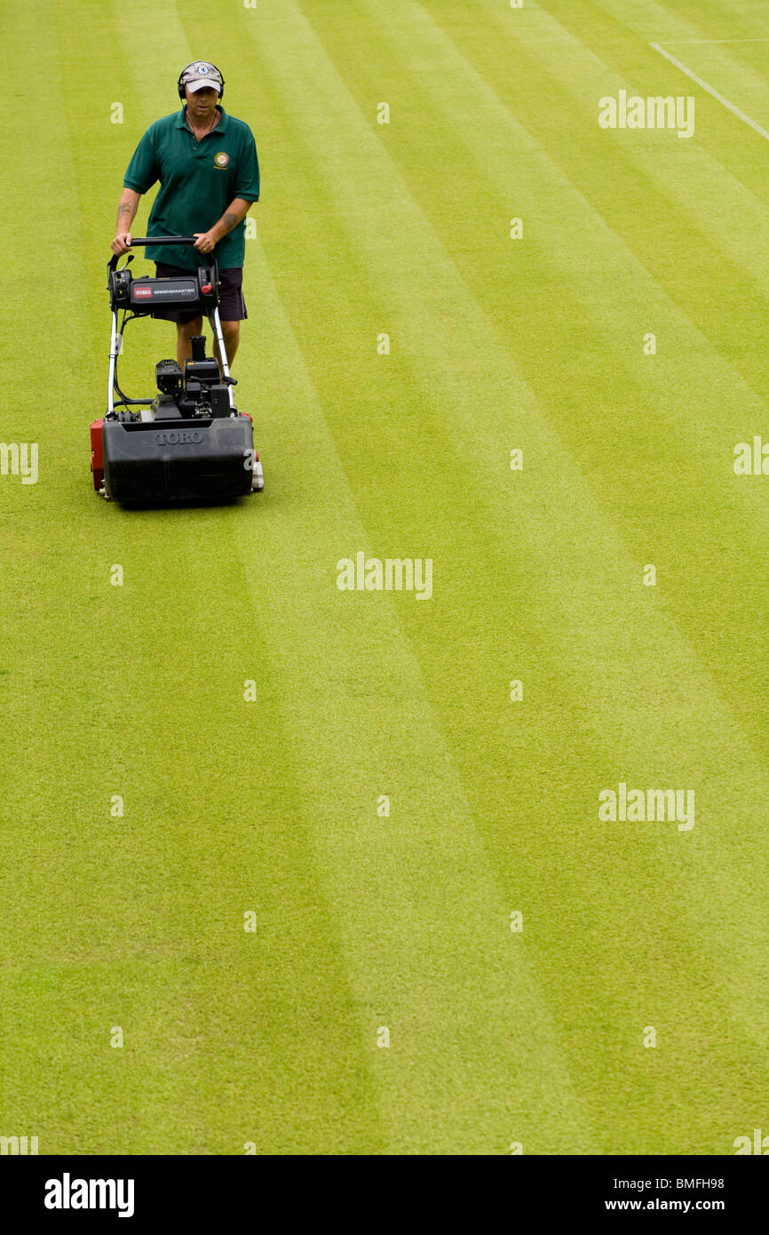 Groundsman at All England Tennis Club, Wimbledon SW19, mowing the lawn tennis Centre Court. UK. Stock Photo