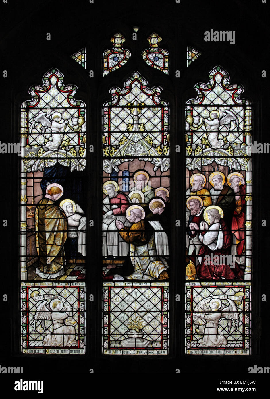 A stained glass window depicting the Dormition of St Mary. She lies on a bed surrounded by the twelve apostles, St Mary's Church Cropredy, Oxfordshire Stock Photo