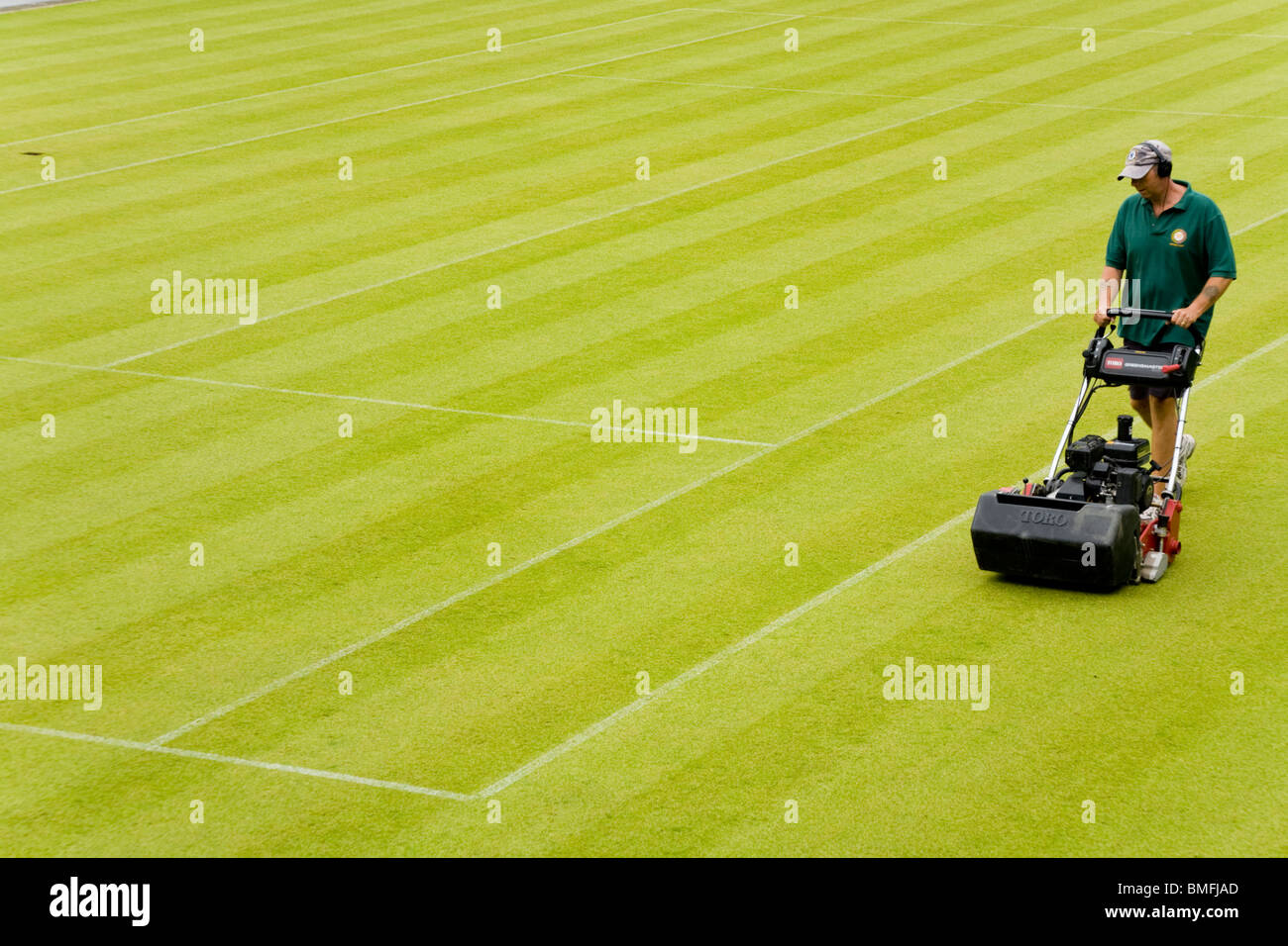 Groundsman at All England Tennis Club, Wimbledon SW19, mowing the Centre Court tennis court lawn . UK. Stock Photo