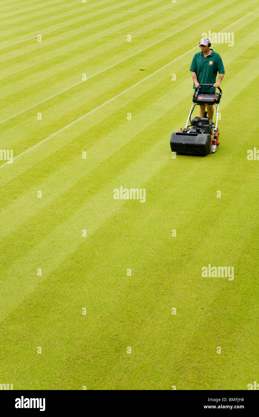 Groundsman at All England Tennis Club, Wimbledon SW19, mowing the Centre Court tennis court lawn . UK. Stock Photo