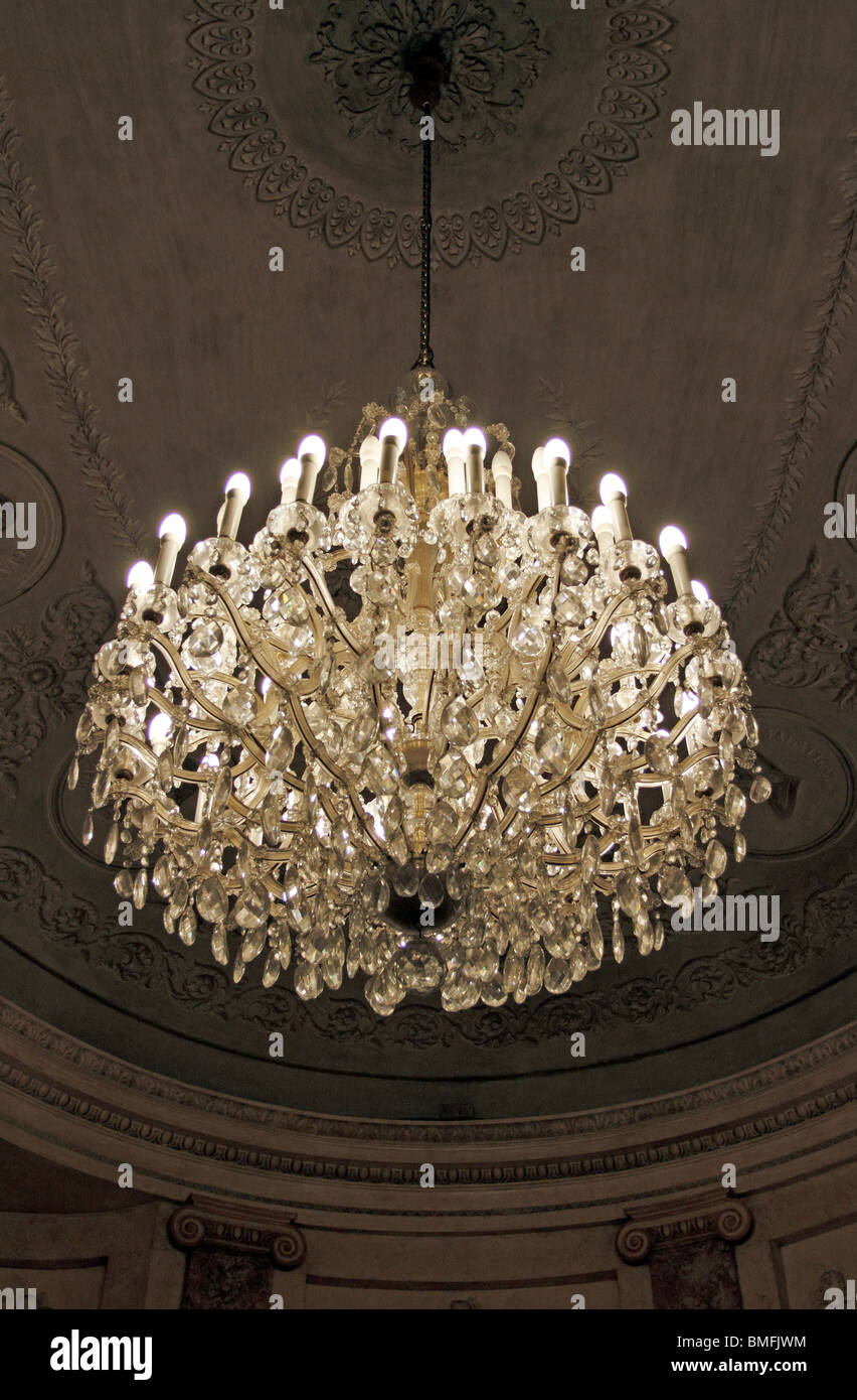 Crystal chandelier hanging in a classically decorated  room with decorative plaster ceiling Stock Photo