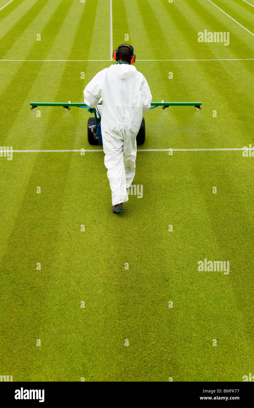 Groundsman at All England Tennis Club, Wimbledon SW19, applying fertilizer feed to the lawn tennis Centre Court. UK. Stock Photo