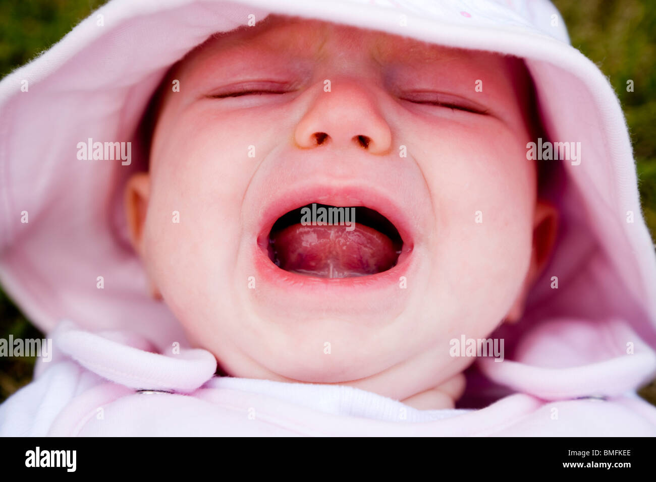 Face of an unhappy baby cry / crying / cries / scream / screaming. Stock Photo