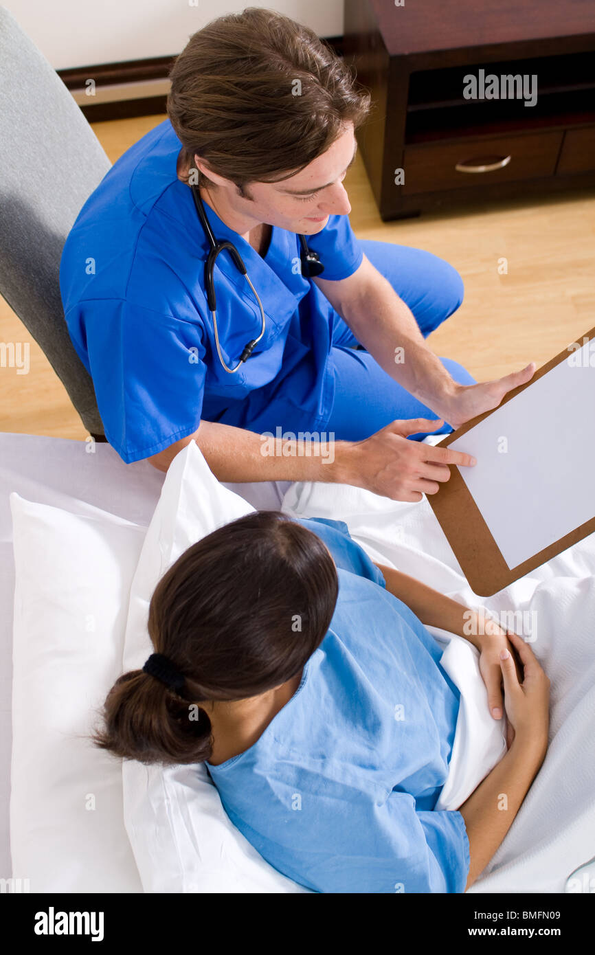 male doctor visiting his patient in the hospital ward and showing her the test result Stock Photo