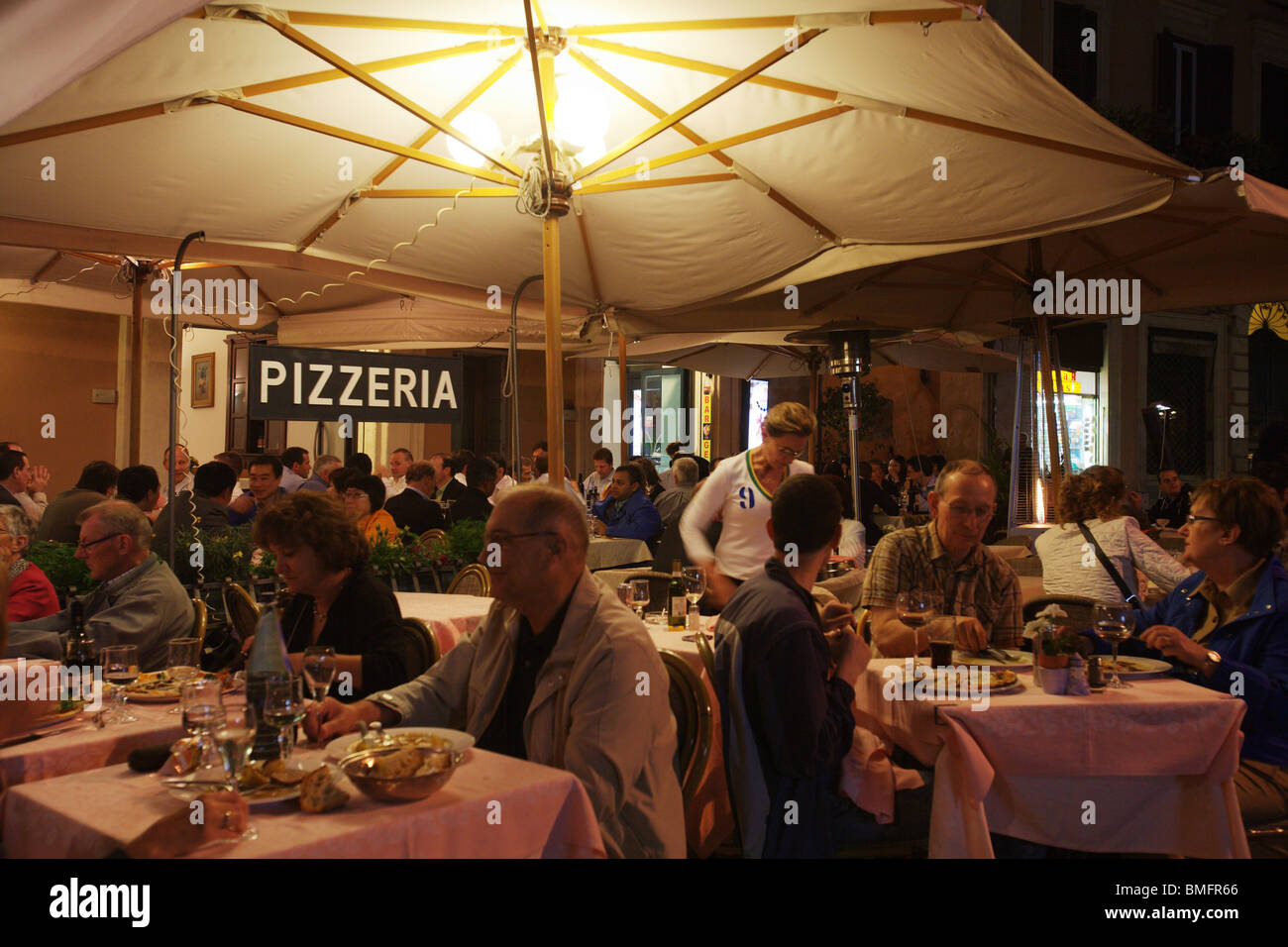 Typical restaurant pizzeria "Tre Scalini" with people eating in the