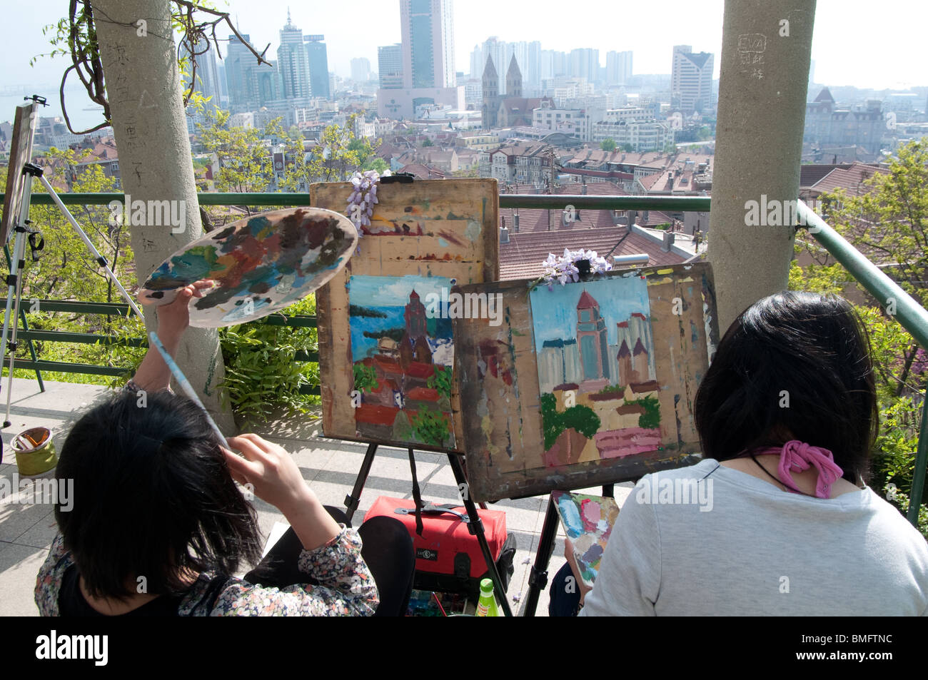Two girls paint an overview of the city, Qingdao, China Stock Photo