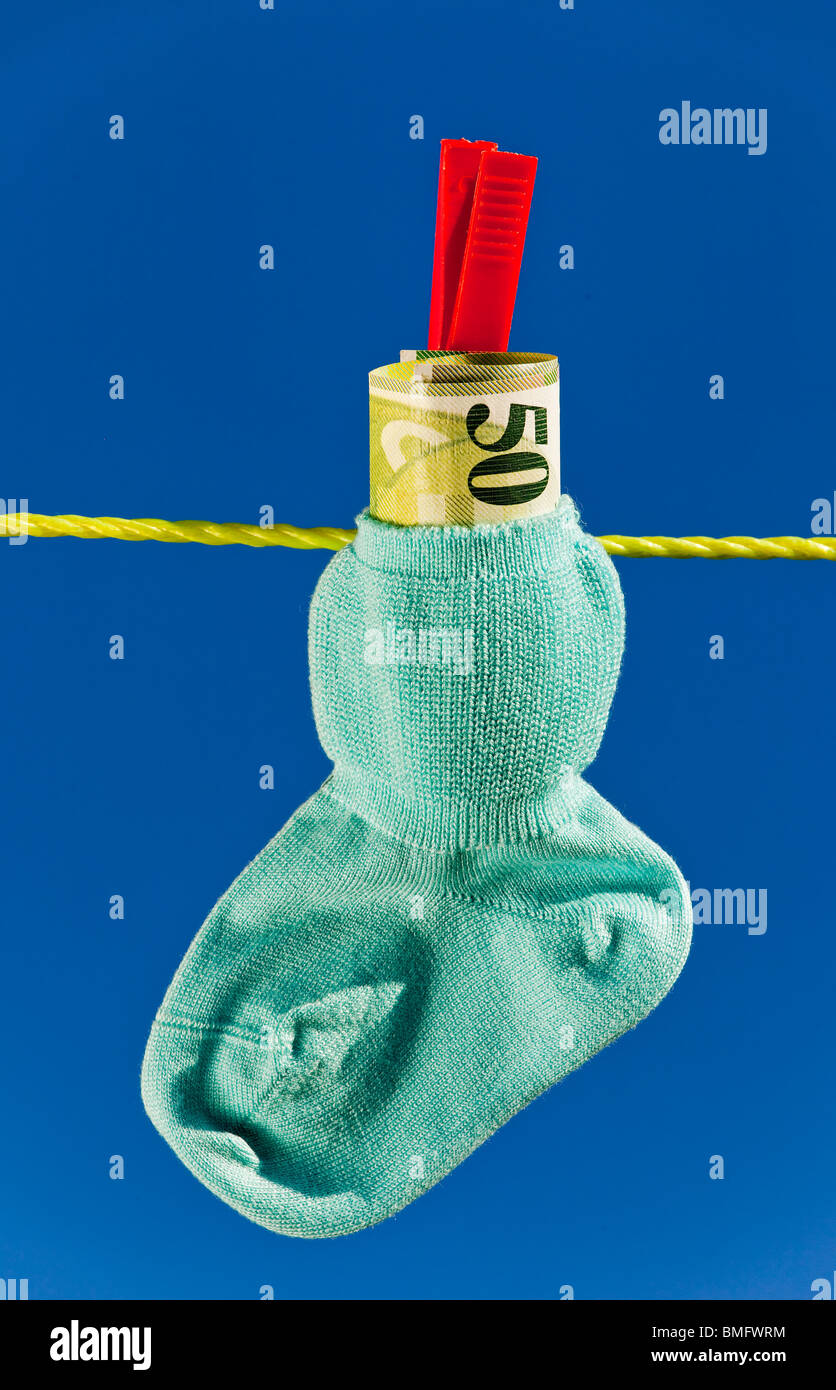 Baby socks on clothesline and Swiss Franc. Blue sky. Stock Photo