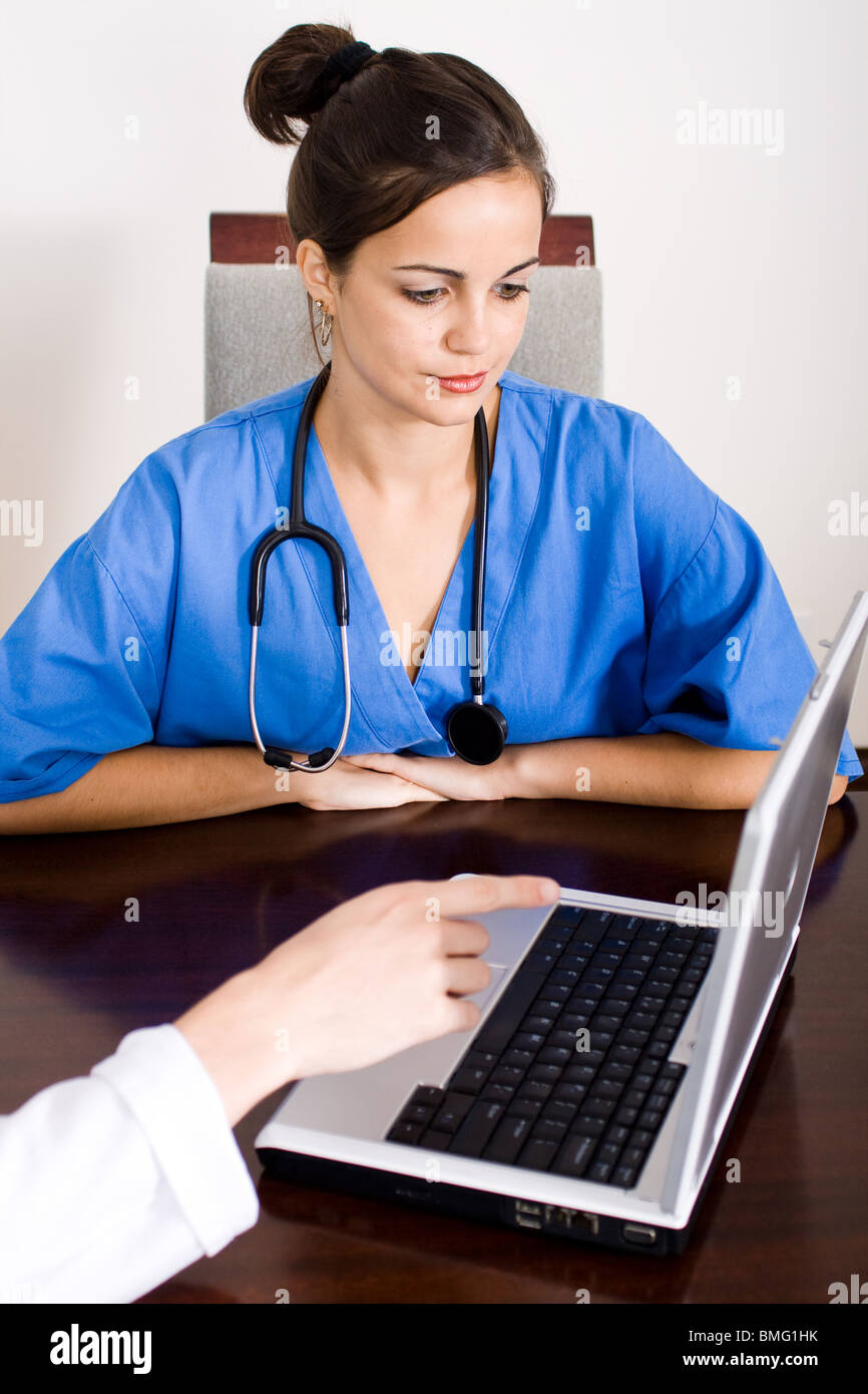 two medical workers using laptop diagnose patient's illness Stock Photo