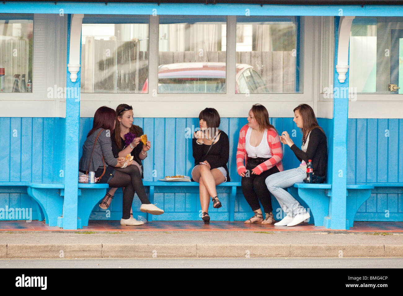 group of young teenage girls in a bus shelter Stock Photo