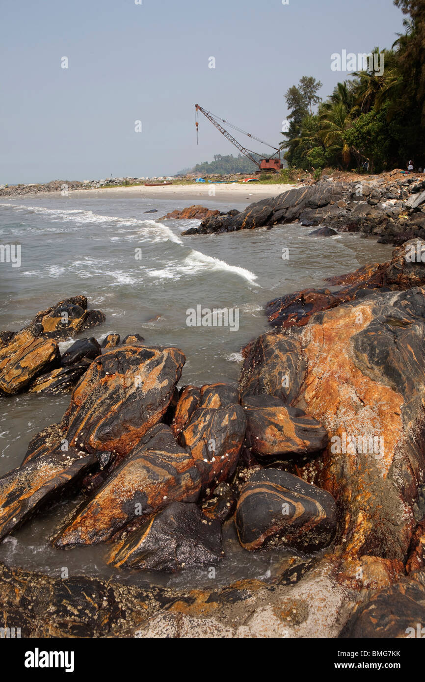 India, Kerala, Mahe (Pondicherry) Union Territory, old rusting crane on rocky breakwater coastal defences Stock Photo