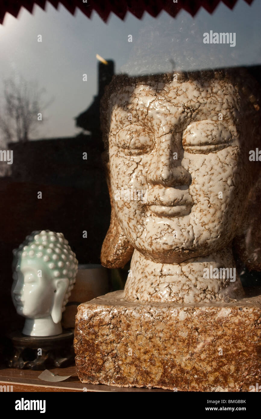 Porcelain Buddha statue displayed in an arts and crafts shop window