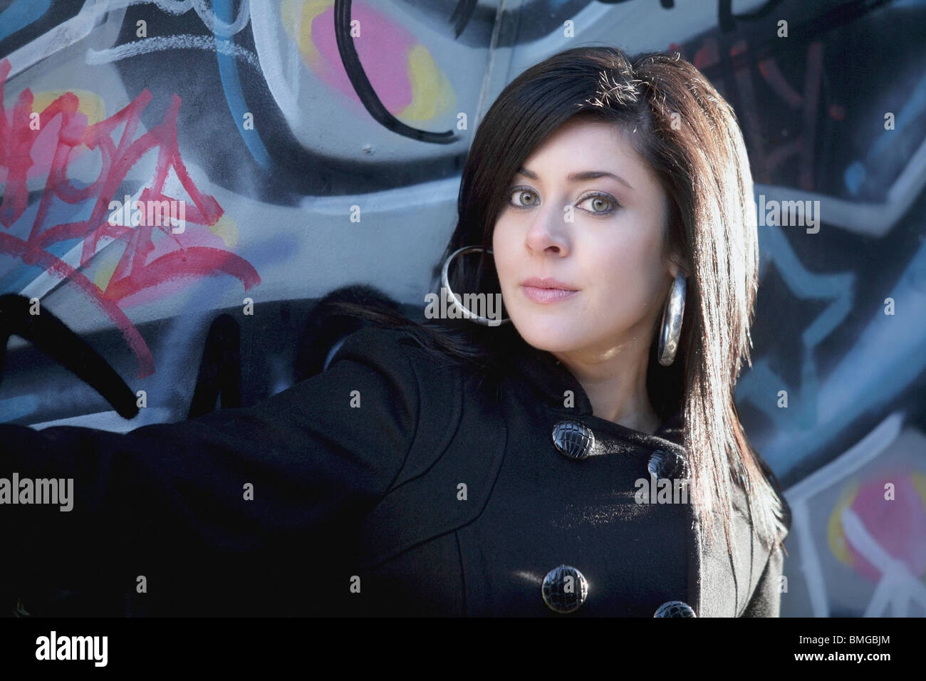 A Young Woman Against A Wall With Graffiti Stock Photo