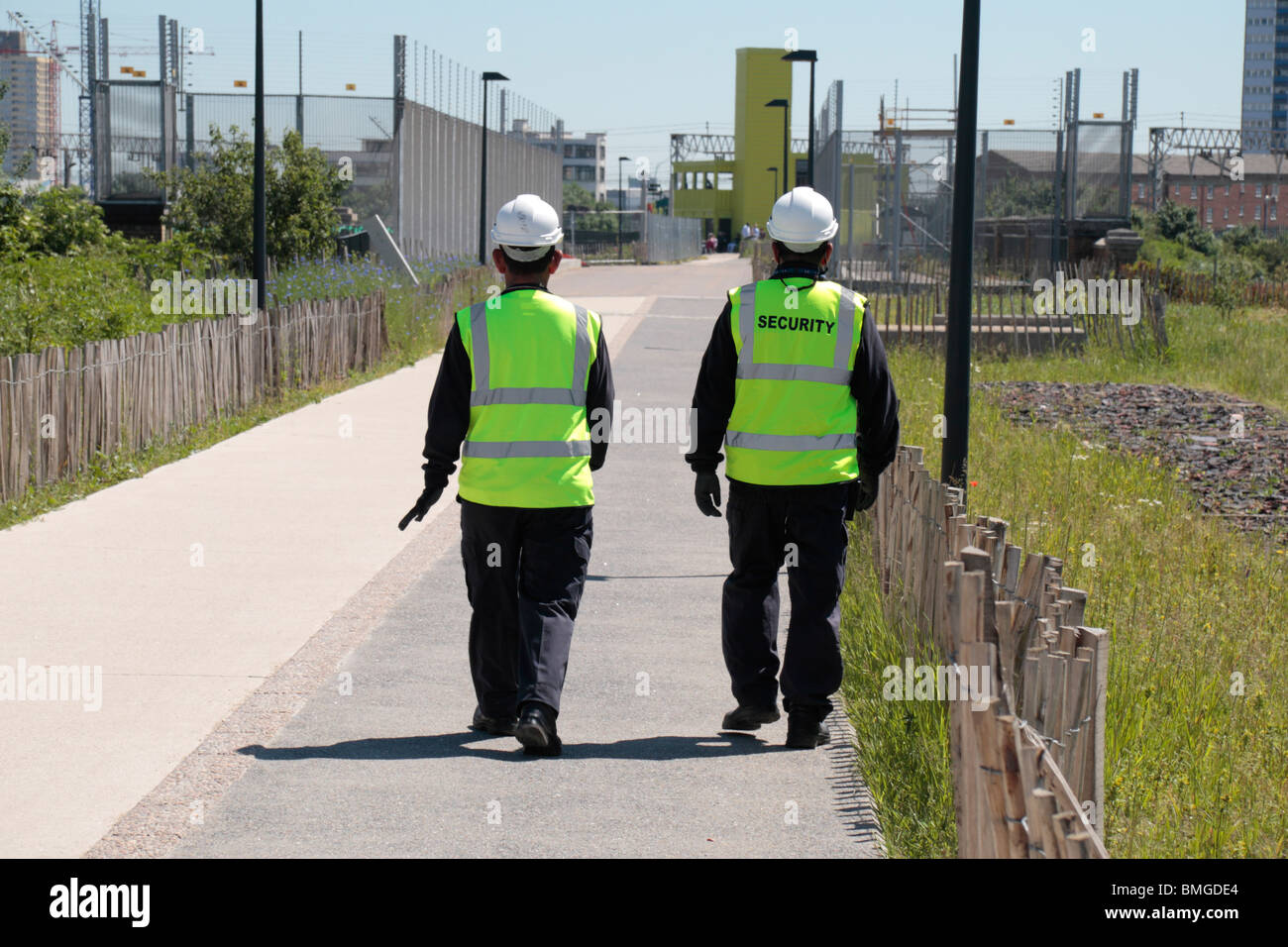 Two security guards on the Greenway, Stratford, beside the construction site for the 2012 Olympics stadium. Jun 2010 Stock Photo