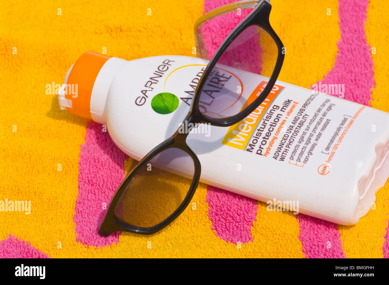Beach Towel A Bottle Of Suncream and A Pair Of Sunglasses Stock Photo