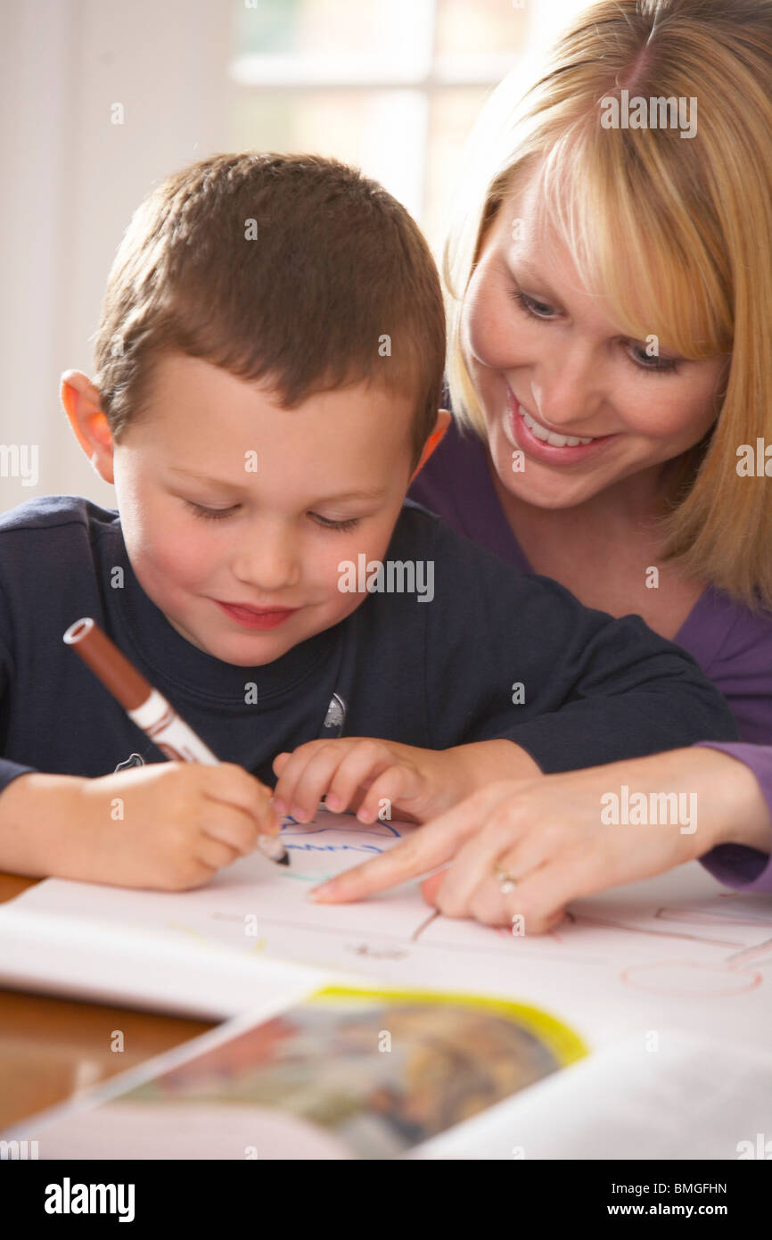 A Mother Doing Workbook Activities With Her Son Stock Photo