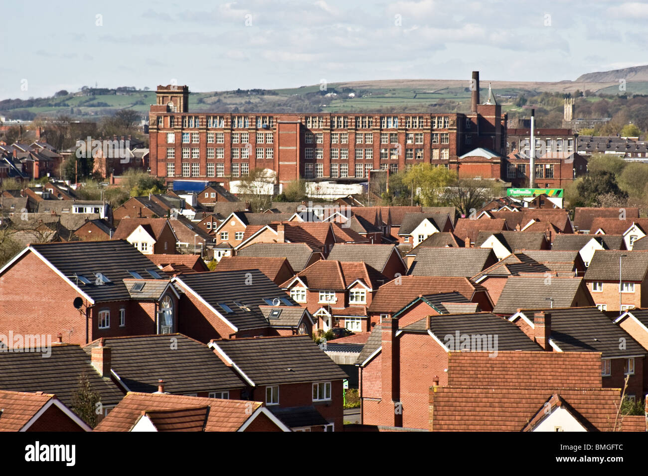 Modern housing estate and old cotton mill (Pilot Mill) with moors beyond, Bury, Greater Manchester, UK Stock Photo