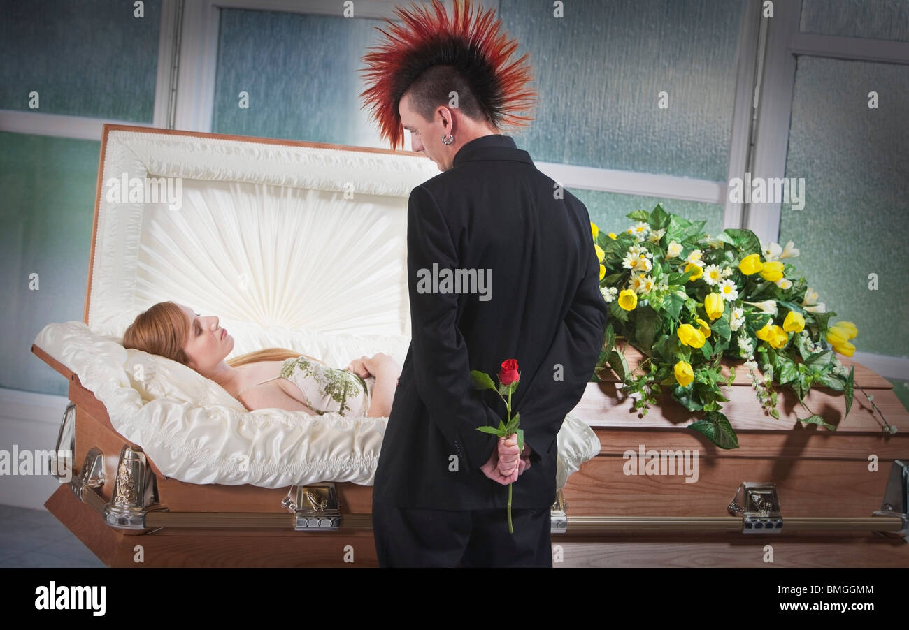 A Man Holding A Rose And Viewing A Deceased Woman Laying In A Coffin Stock Photo