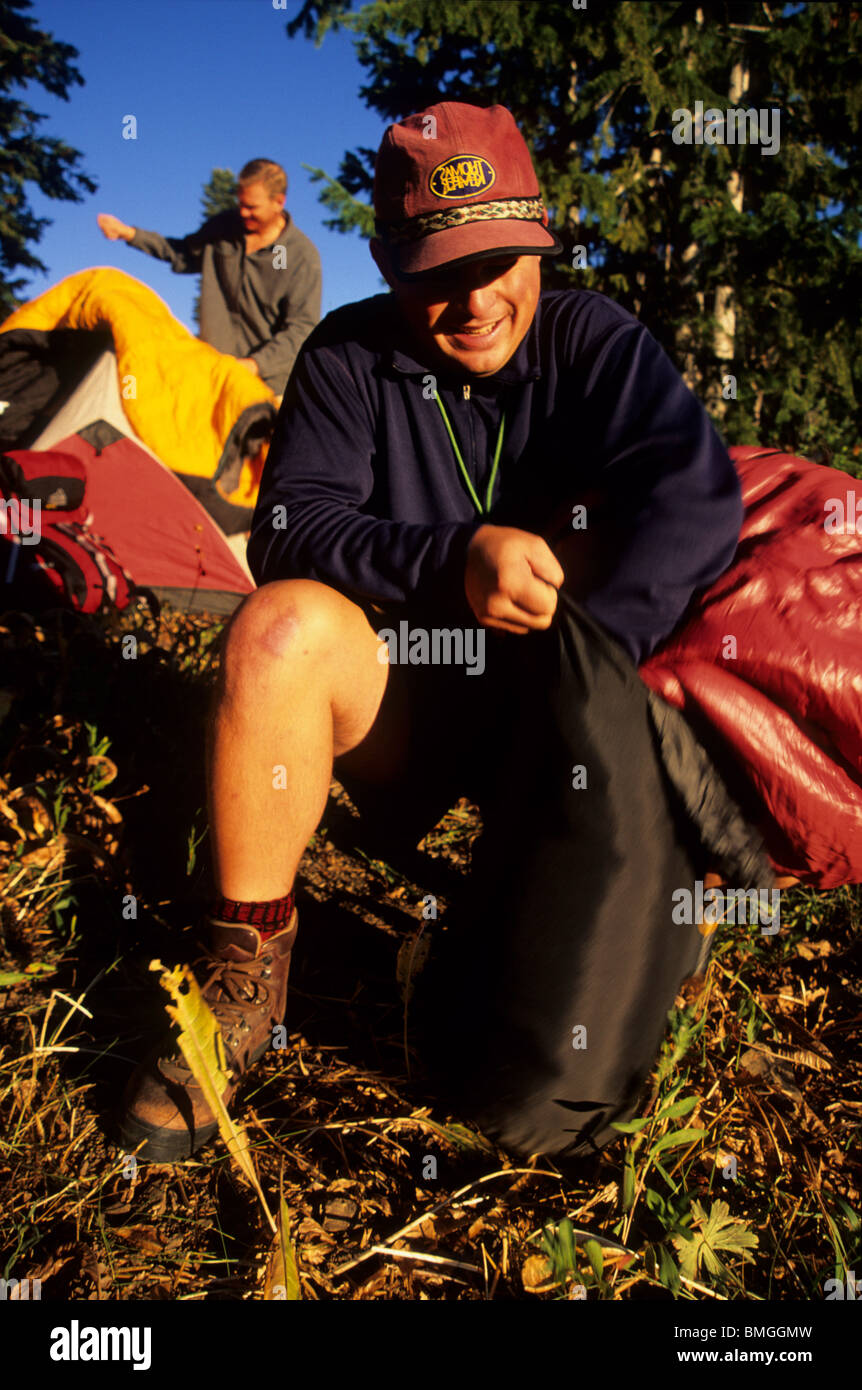 Man stuffing sleeping bag into sack Stock Photo Alamy