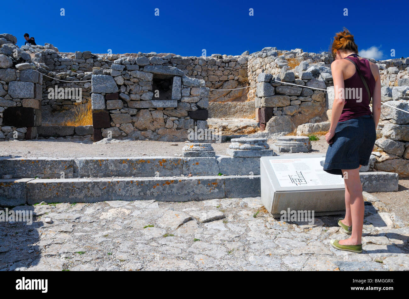 A visitor at the ruins of the ancient city of Thera on top of Mount Mésa Vounó, Santorini Island, Greece. Stock Photo