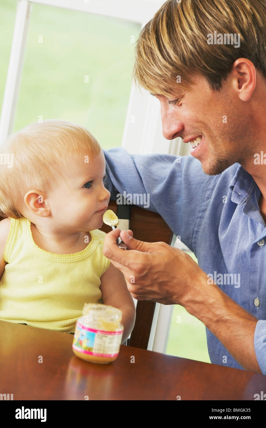 A Father Feeding His Young Daughter Stock Photo