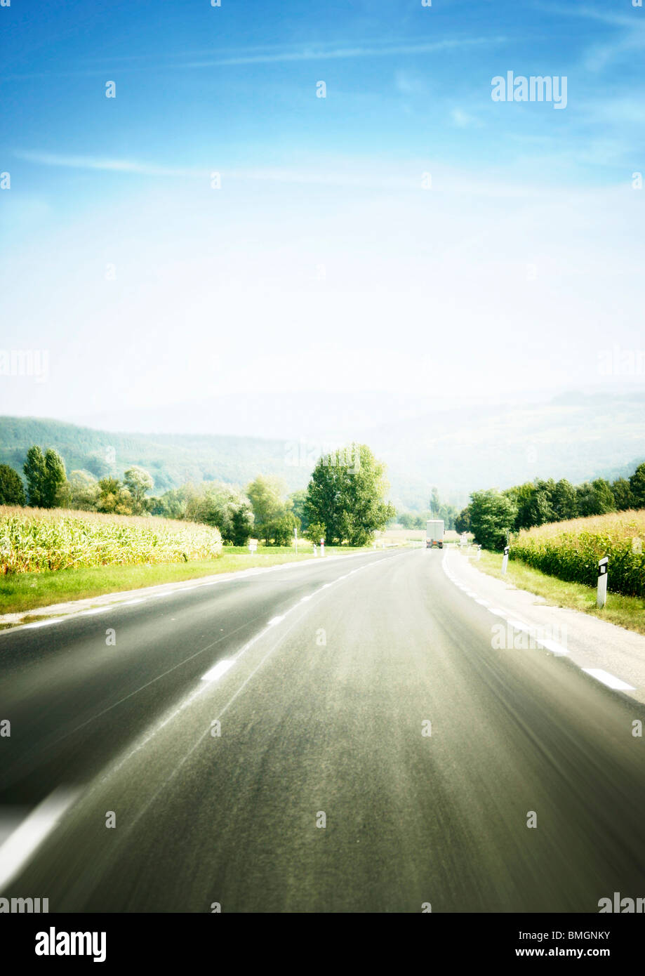 Mountain landscape - empty highway, clouds and the blue sky Stock Photo