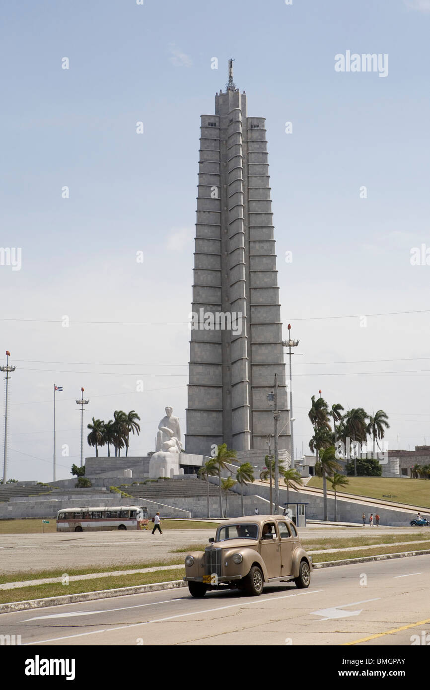 A classic car in Cuba passes a building in the Plaza de Revolution. Stock Photo