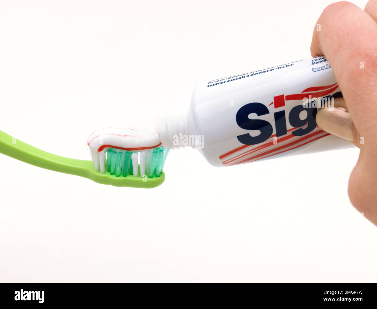 Squeezing Toothpaste From Tube On To Green Toothbrush Stock Photo Alamy