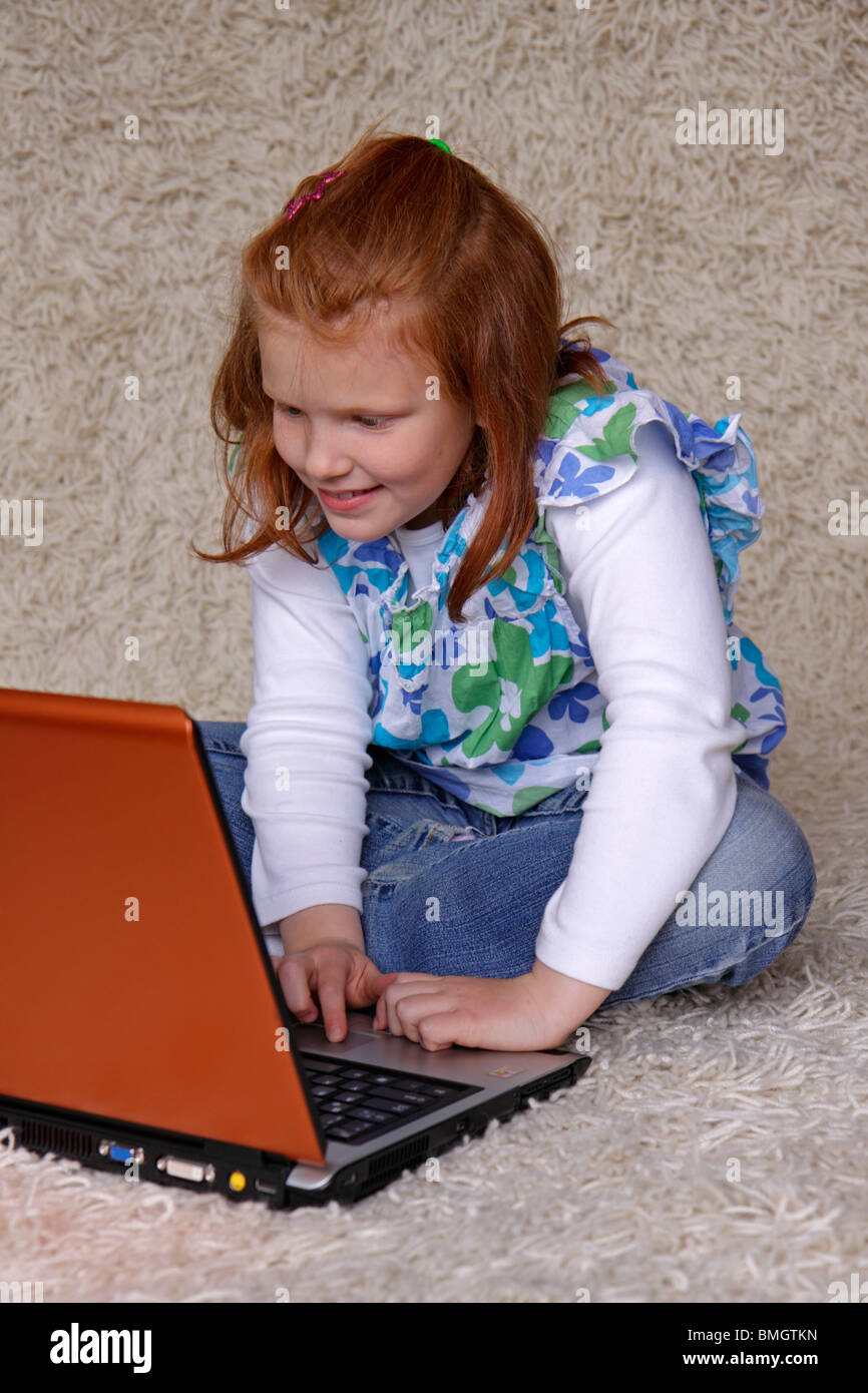 portrait of a young girl sitting on the floor with her laptop Stock ...